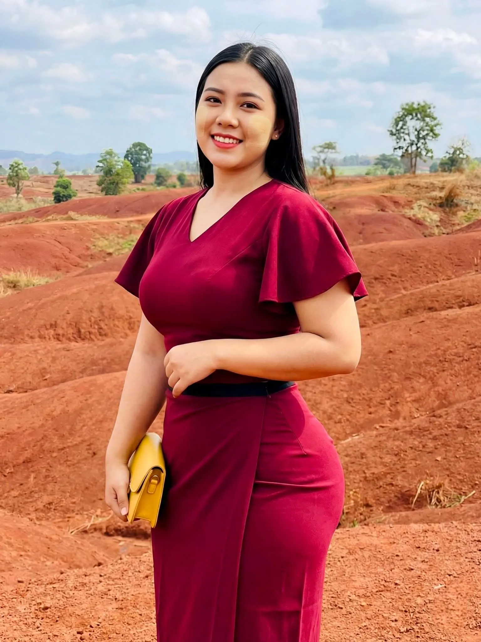 Modest One Hand Holding a Small Bag pose in Myanmar traditional outfit, relaxed hands, natural light, family-friendly.