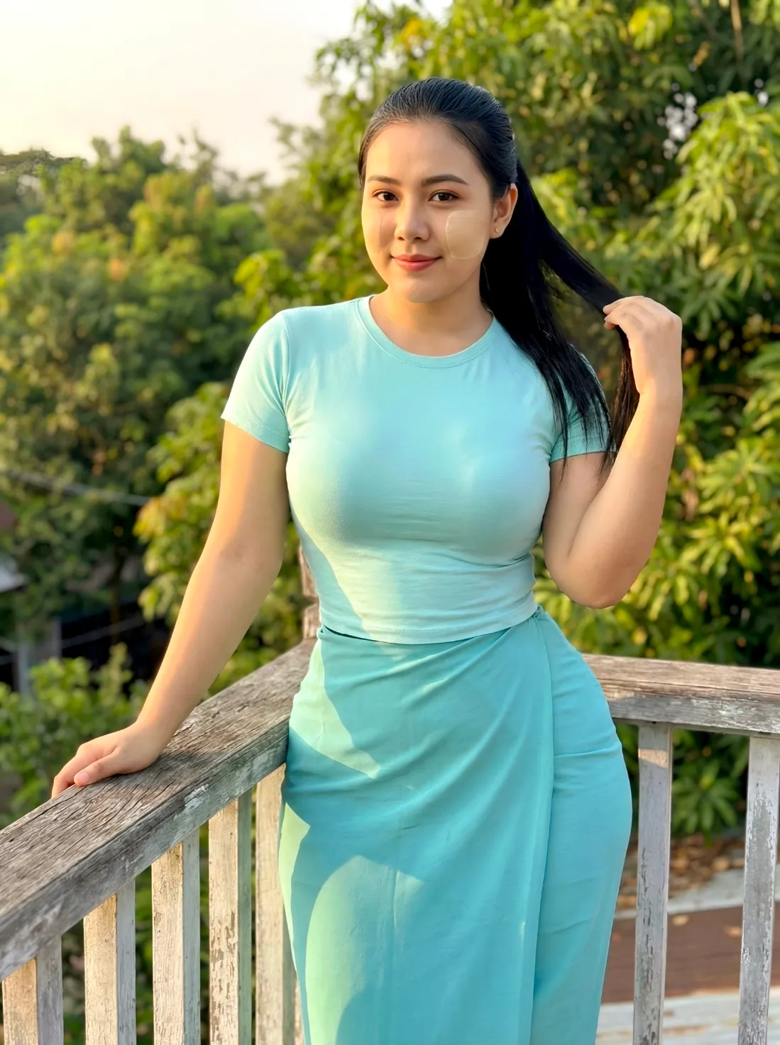 Modest One Hand Near Hair (Natural & Calm) pose in Myanmar traditional outfit, relaxed hands, natural light, family-friendly.