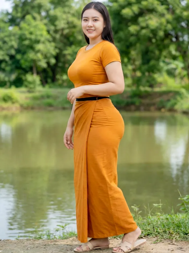 Modest Walk Past a Simple Background pose in Myanmar longyi, natural movement, clean background, family-friendly.